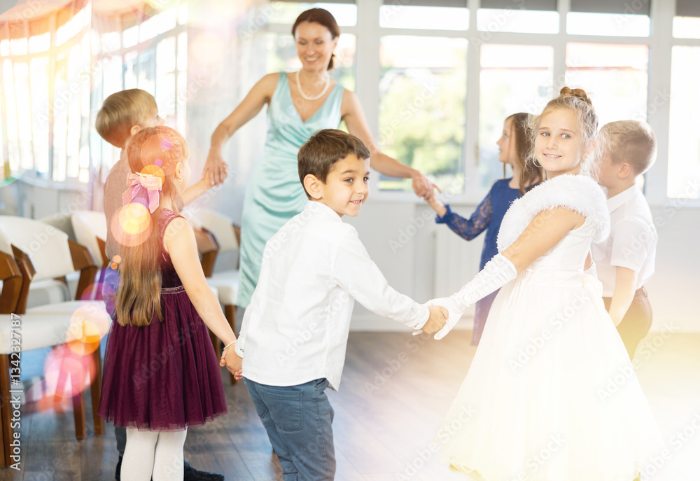 Fototapeta premium Children holding hands and dancing in a round dance - festive pastime