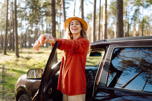 Beautiful woman near car and enjoy the nature around - concept of off grid vacation and trip with wood and trees - people enjoy the outdoor leisure activity with vehicle