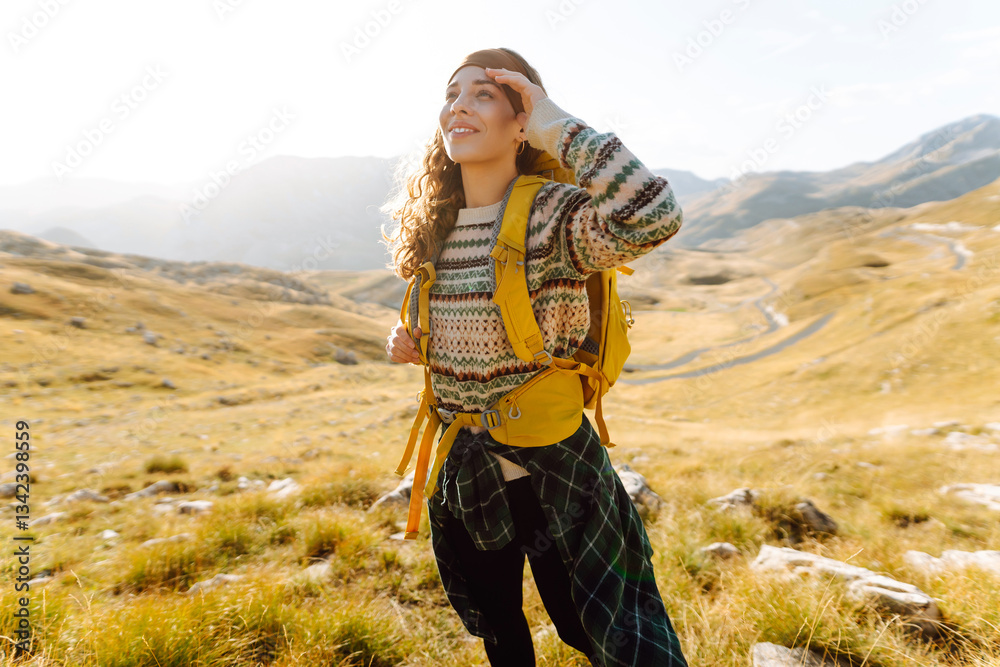 Naklejka premium Female tourist standing at mountains with backpack admiring landscape. Hiking. Europe travel
