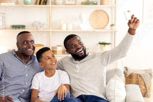 Φωτογραφία In a cozy living room, a father, son, and uncle share laughter while taking a selfie