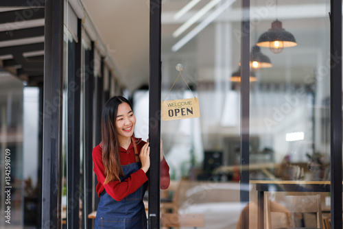 Wallpaper Mural Asian Happy business woman is a waitress in an apron and stands at the door with a sign Open waiting for customers , cafes and restaurants Small business concept.
 Torontodigital.ca