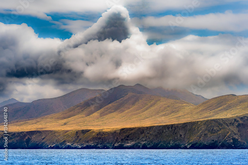 Obraz na płótnie Striking dramatic skies hang over the coastal shores of the Channel Islands during a colorful Springtime day w salonie