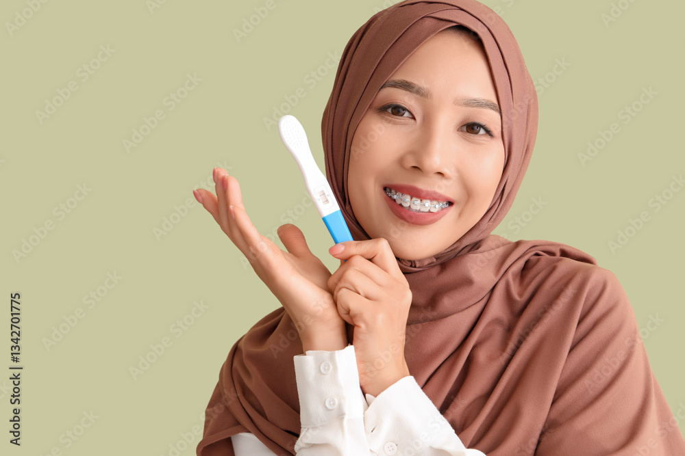 Young Muslim woman with pregnancy test on green background, closeup Young Muslim woman with pregnancy test on green background, closeup