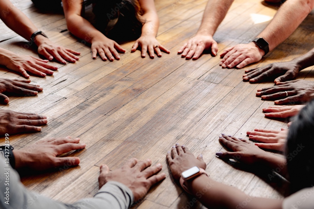 Diverse hands of various ethnicities and genders form a circle on a wooden floor. Unity and diversity are highlighted by the different hands and skin tones. Diverse hands on wooden floor in cicrle. Diverse hands of various ethnicities and genders form a circle on a wooden floor. Unity and diversity are highlighted by the different hands and skin tones. Diverse hands on wooden floor in cicrle.
