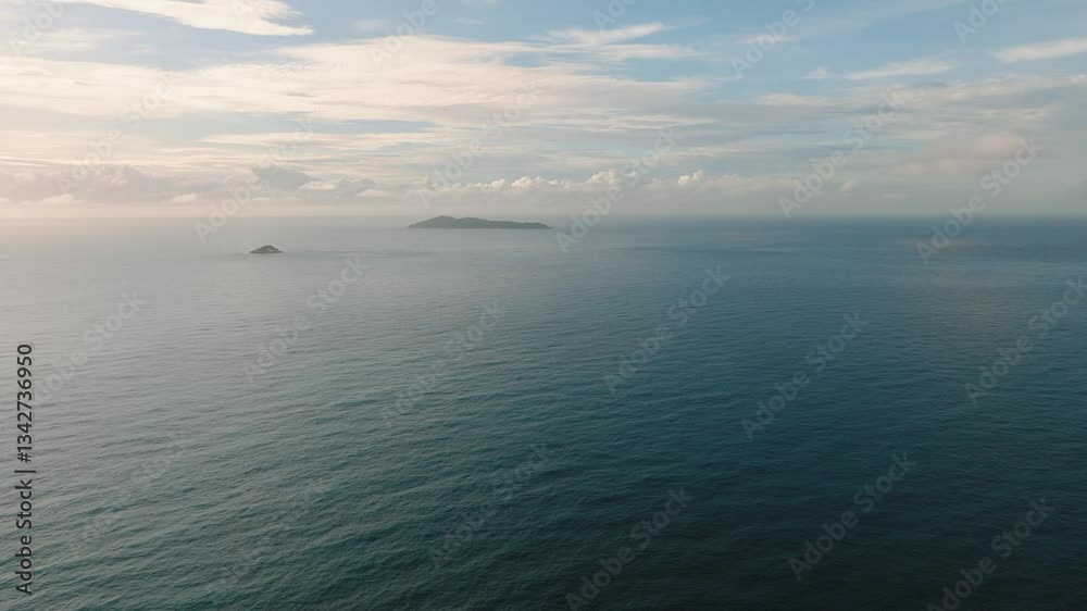 A breathtaking view of the endless ocean with small distant islands visible on the horizon under a serene sky. Seychelles. A breathtaking view of the endless ocean with small distant islands visible on the horizon under a serene sky. Seychelles.