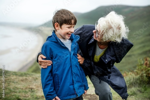 Joyful elderly woman with young boy outdoor nature. Caucasian grandmother and grandson enjoying a day outdoors. Grandmother and grandson have a good time outdoor nature. Grandmother hug her grandson