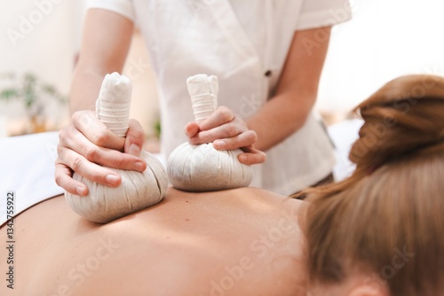 Foto A person receiving a relaxing herbal compress massage