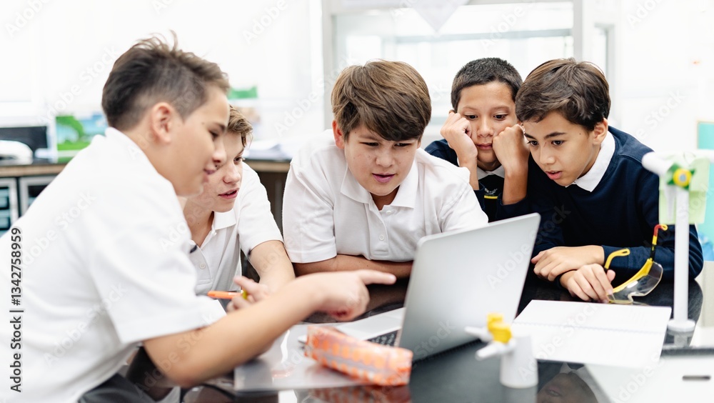 Group of student boys focus on laptop, collaborate in classroom. Boys in school uniforms teamwork, learn together, discuss ideas in classroom. Student focus on group project, work together on laptop Group of student boys focus on laptop, collaborate in classroom. Boys in school uniforms teamwork, learn together, discuss ideas in classroom. Student focus on group project, work together on laptop