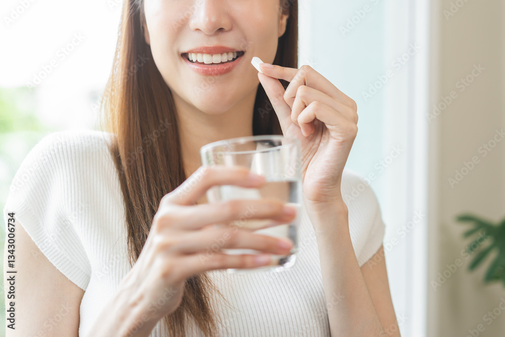 Dietary supplement, healthy positive asian young woman hand holding herb pill, take vitamin nourish body for treatment beauty skin, taking medicine with glass of water at home. Health care concept. Dietary supplement, healthy positive asian young woman hand holding herb pill, take vitamin nourish body for treatment beauty skin, taking medicine with glass of water at home. Health care concept.