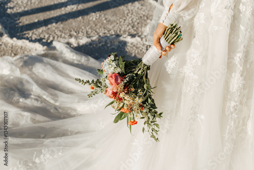 Detail Shot of Bride with her Bouquet, floral wedding dress, and train
