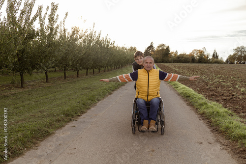 Family with a teenage son is walking in the orchard photo