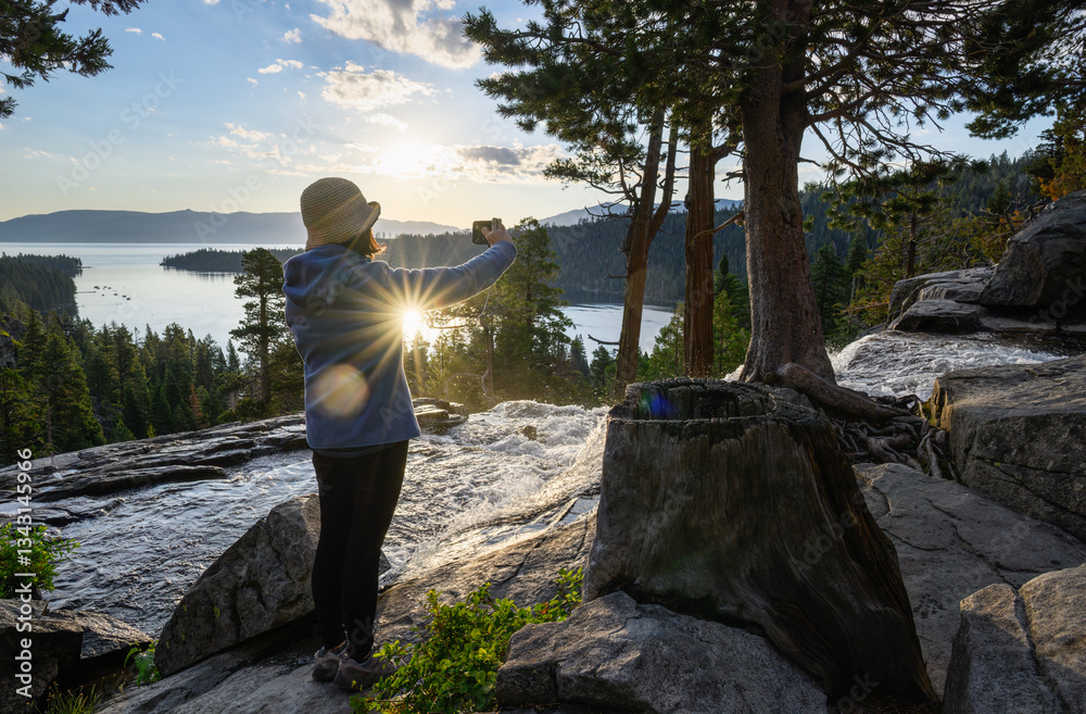 Woman taking photos of Lower Eagle Falls using a smartphone. Emerald Bay. Lake Tahoe. California.