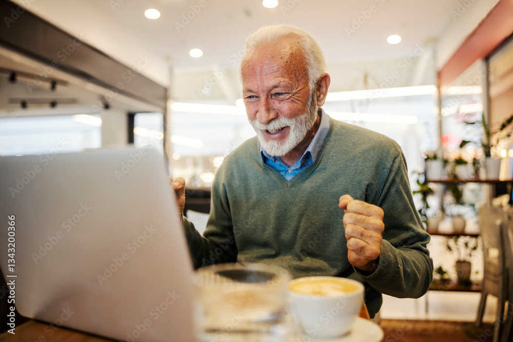 An old man is celebrating victory and looking at laptop in coffee shop.
