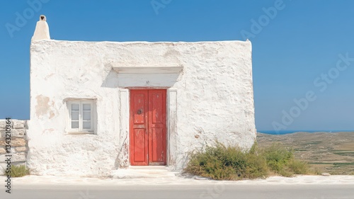 Whitewashed House with Red Door on Sunny Hillside photo