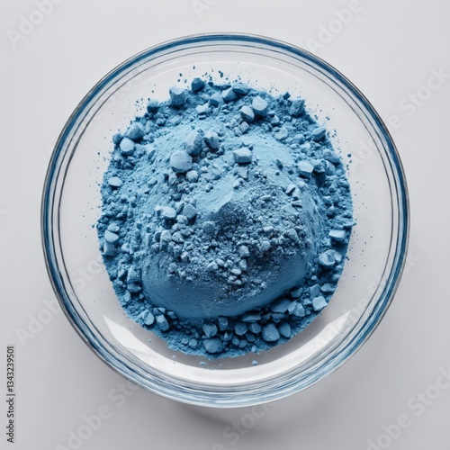 Top view of blue powder and rocks in clear bowl