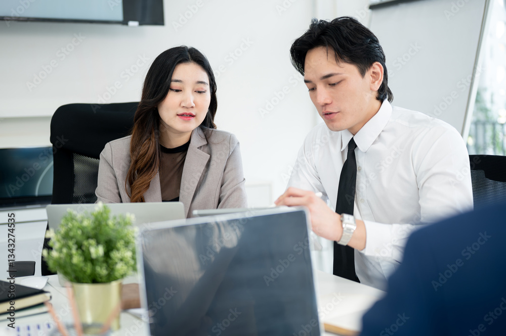 Male office worker is pointing stylus at tablet showing business data to female coworker in meeting. Male office worker is pointing stylus at tablet showing business data to female coworker in meeting.