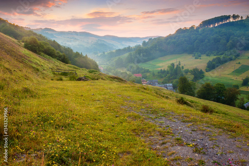 Obraz na płótnie landscape of rural valley with dawn sky. nature in summer. green meadow in mountain and forest on hill. scenic travel view. beautiful countryside background with grass for outdoor tourism w salonie