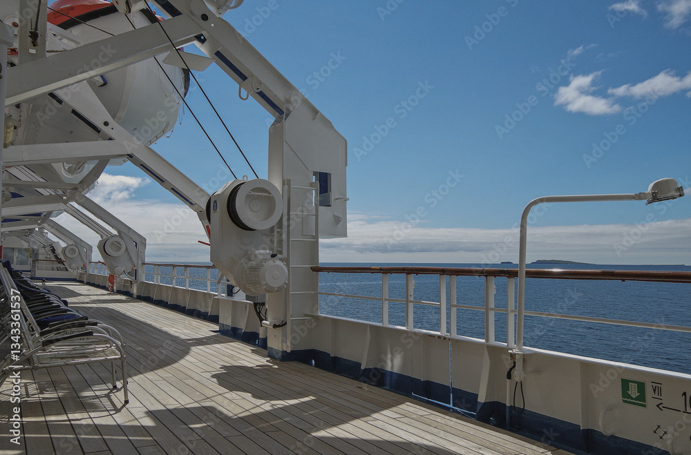 Outdoor promenade boat deck patio terrace onboard classic expedition cruiseship cruise ship liner during cruise through Orkney Islands archipelago coast line