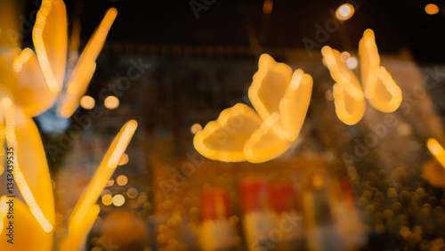 Obraz na płótnie Blurred christmas lights creating ethereal butterfly shapes against a dark, out-of-focus background, adding a touch of magic to the night w salonie