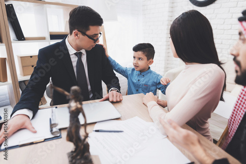 Divorce lawyer in office with arab husband and wife. Son is choosing mother.