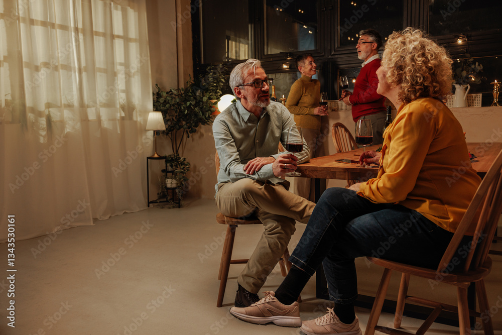 Fototapeta premium Group of senior adults enjoying red wine and celebrating retirement