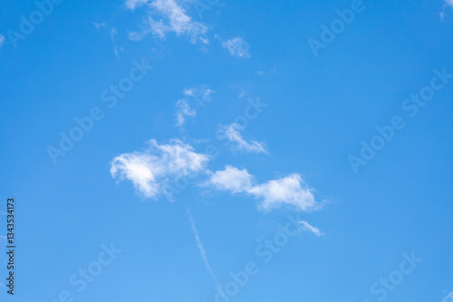 Clear Blue Sky with Small Wispy Clouds and Contrail