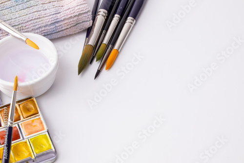 Watercolor painting tools arranged on a white background