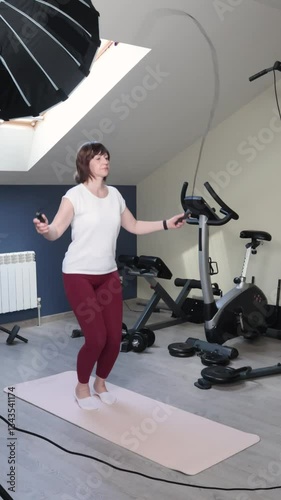 Female vlogger 50s video of smart watches and jumping rope at home. Active sports. Equipment in exercise room. Health, weight loss and exercise. 