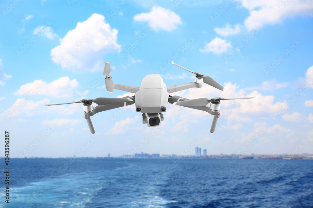 Naklejka premium Drone with camera flying over sea. Unmanned aerial vehicle for surveillance
