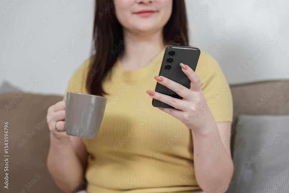 Coffee Break and Smartphone Communication. A woman enjoying a coffee while checking her smartphone at home. Coffee Break and Smartphone Communication. A woman enjoying a coffee while checking her smartphone at home.
