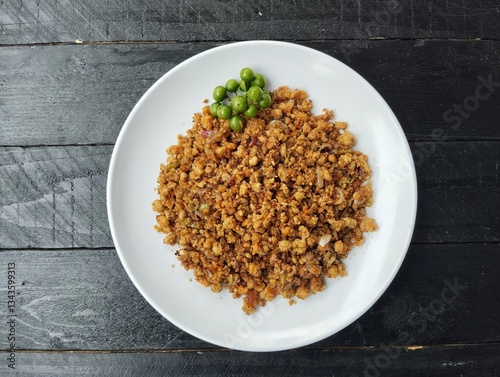 Oseng-oseng oncom or Indonesian food culinary, on plate on black wooden table background