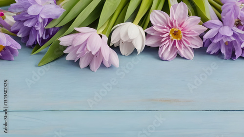 Colorful spring flowers lying on light blue wooden planks