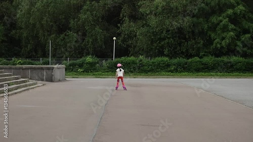 a girl rides in a helmet and knee pads on roller skates