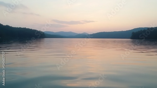 Peaceful Sunset Over Calm Lake and Silhouetted Hills