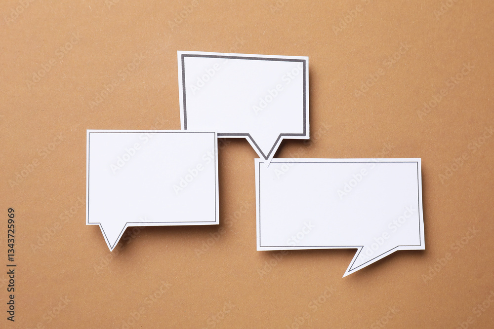 Blank speech bubbles on brown background, top view. Space for text Blank speech bubbles on brown background, top view. Space for text