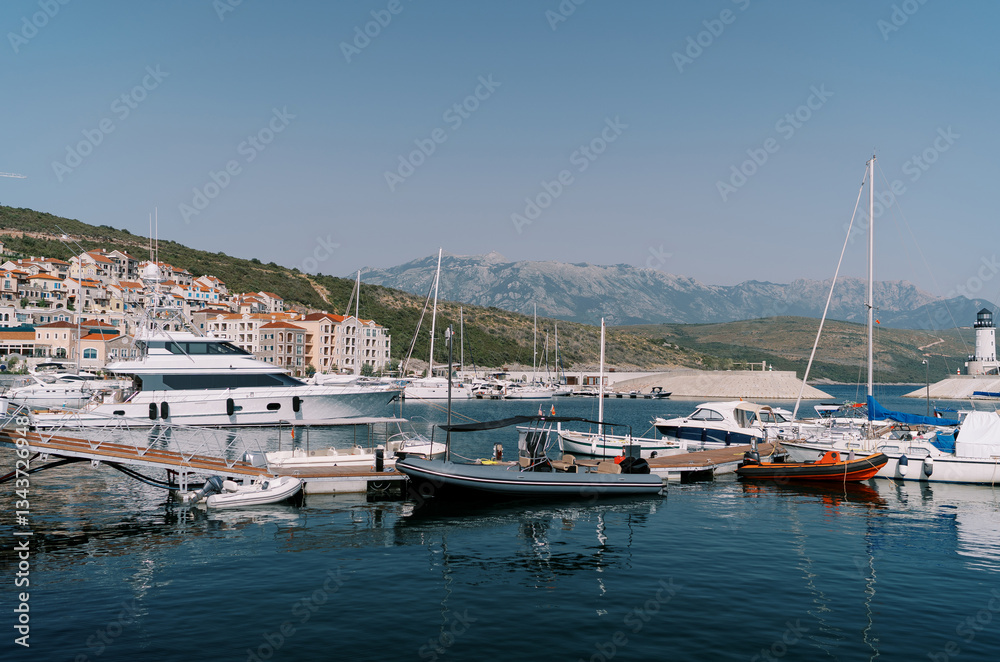 Inflatable motor boats stand next to yachts at the marina berths Inflatable motor boats stand next to yachts at the marina berths