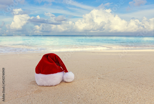 Christmas background with red hat on the white Caribbean sand.