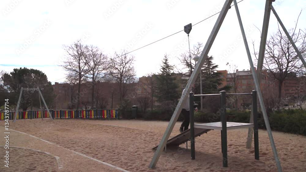 Young man using zip line in a playground in Madrid Young man using zip line in a playground in Madrid
