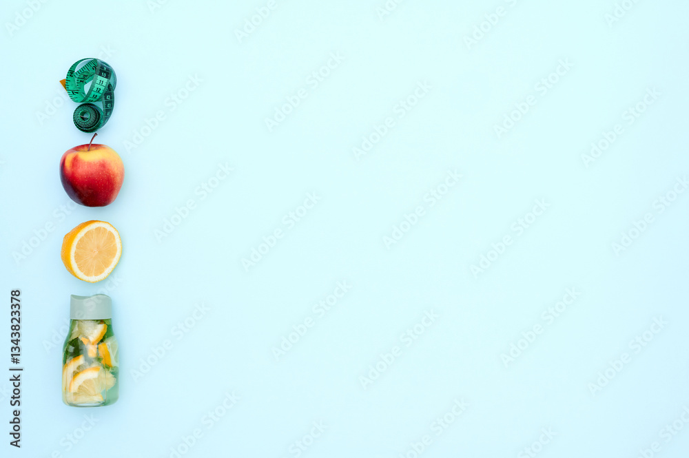 Blank space for text. Red apple, orange, roulette and water bottle on turquoise background. Top view. Blank space for text. Red apple, orange, roulette and water bottle on turquoise background. Top view.