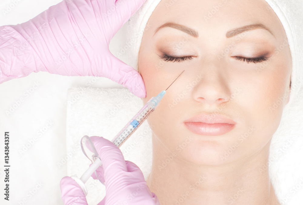 Beautiful woman gets an injection in her face isolated on white Beautiful woman gets an injection in her face isolated on white