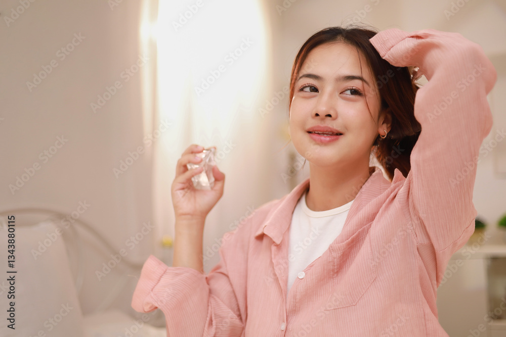 Beautiful woman spraying perfume in her bedroom. Health and wellness concept. Lifestyle. Beautiful woman spraying perfume in her bedroom. Health and wellness concept. Lifestyle.