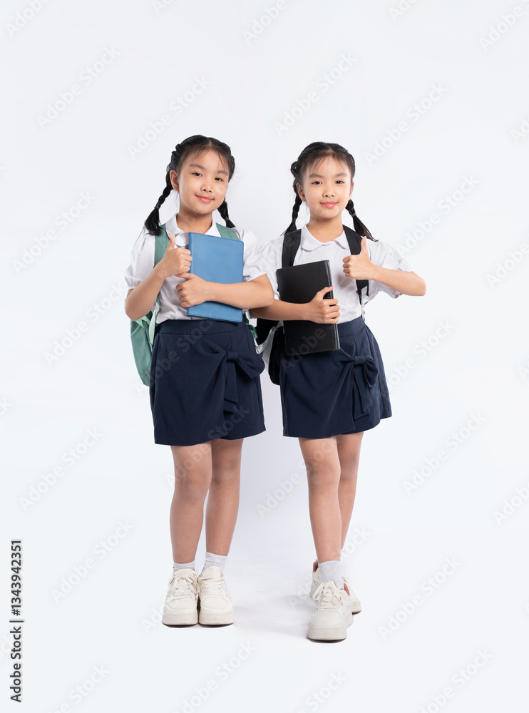 Schoolgirls in uniform give thumbs up, ready for class. Cheerful kids with books and backpacks pose. Schoolgirls in uniform give thumbs up, ready for class. Cheerful kids with books and backpacks pose.