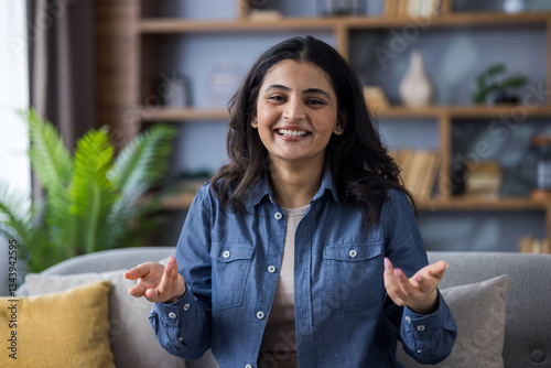 Cuadro en lienzo Close-up portrait of a young Indian woman in a denim shirt sitting on a sofa at