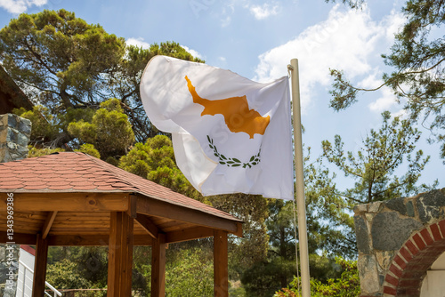 Obraz na płótnie National flag of Cyprus flutters in the wind on pole at public park in front of