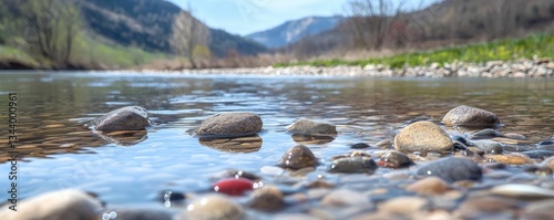 Discover serenity in this captivating landscape photograph A Majestic river curving through rolling hills, shimmering transparency revealing colorful pebbles below Experience the calming flow of