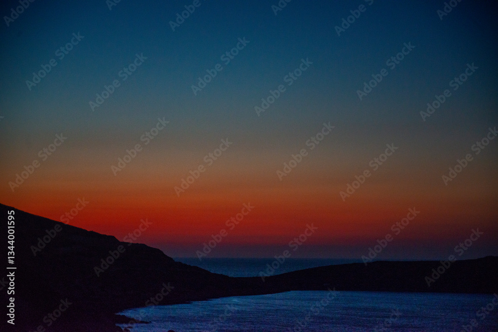 Fototapeta premium Sunset in a bay near Sitia, Crete, where the last colors of the day are reflected in the sea
