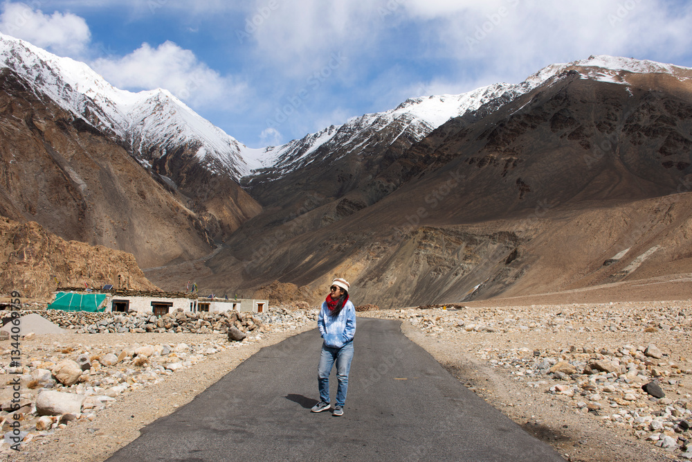 Obraz premium Thai woman travel visit stand and walking for take photo on Pangong lake road with view landscape himalayan mountains range while winter season at Leh Ladakh in Jammu and Kashmir, India