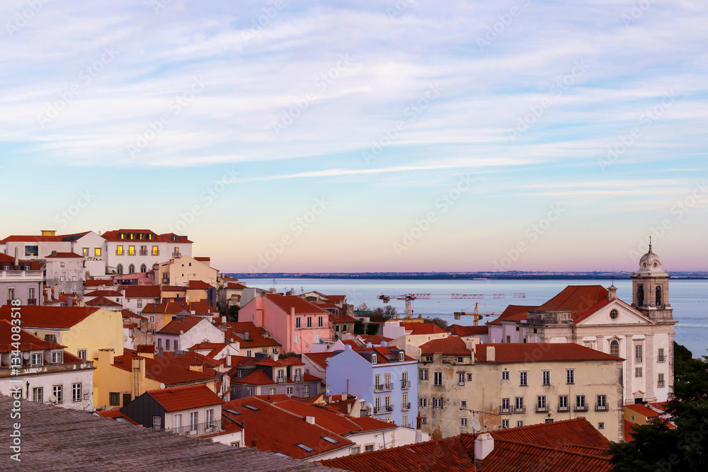 Fototapeta premium Sunset over Alfama in Lisbon, Portugal, from Miradouro das Portas do Sol viewpoint.
