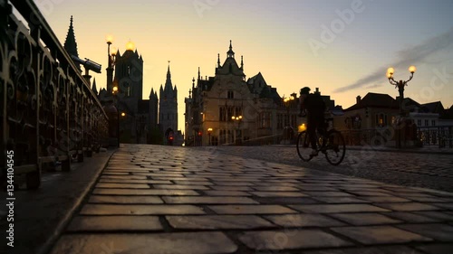 Dawn Bicycles St Michael’s Bridge Ghent Belgium 4K UHD. The view on Saint Michael’s Bridge to Nicholas church as bicycles cross at dawn. Ghent, Belgium. 4K, UHD.
