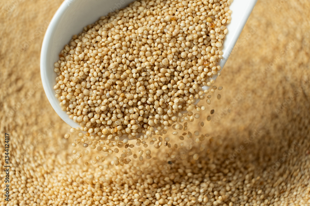 Organic amaranth grains spilling out of spoon close-up. Organic amaranth grains spilling out of spoon close-up.